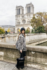 Frankreich, Paris, lächelnde junge Frau vor Notre Dame - MGOF02724