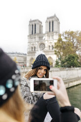 Frankreich, Paris, Touristin fotografiert ihre Freundin vor Notre Dame - MGOF02725