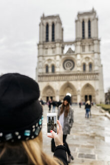 France, Paris, tourist taking picture of her friend in front of Notre Dame - MGOF02728