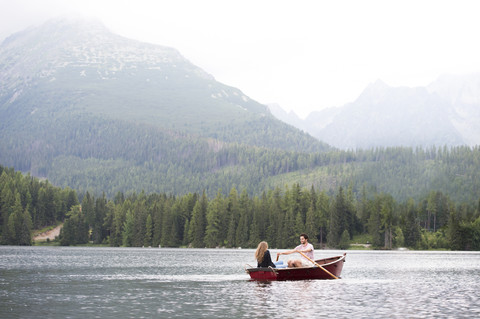 Junges Paar im Ruderboot auf dem See, lizenzfreies Stockfoto