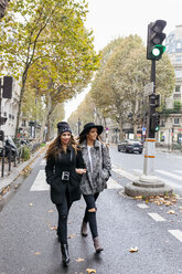 Paris, Frankreich, zwei junge Frauen gehen auf der Straße - MGOF02740