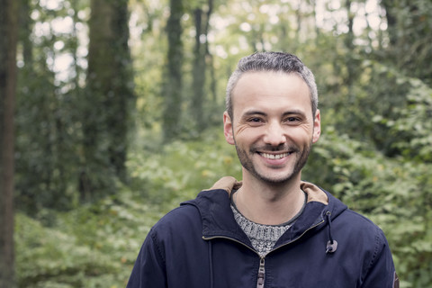 Porträt eines lächelnden Mannes im Wald, lizenzfreies Stockfoto