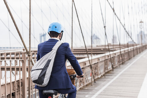USA, New York City, man on bicycle on Brooklyn Bridge - UUF09665