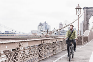 USA, New York City, man on bicycle on Brooklyn Bridge - UUF09670