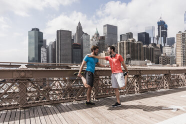 USA, New York City, zwei Sportler beim Stretching auf der Brooklyn Brige - UUF09683