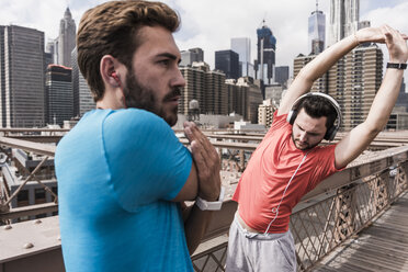 USA, New York City, zwei Sportler beim Stretching auf der Brooklyn Brige - UUF09684