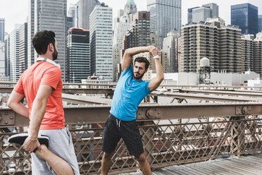 USA, New York City, zwei Sportler beim Stretching auf der Brooklyn Brige - UUF09685