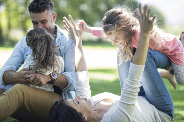 Parents playing with daughters on meadow - ZEF12337