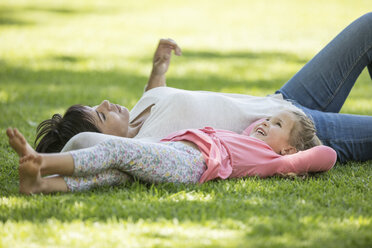 Mother and daughter lying in grass - ZEF12343