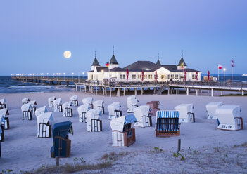 Deutschland, Usedom, Ahlbeck, Blick auf Seebrücke mit vermummten Strandkörben im Vordergrund in der Abenddämmerung - SIEF07237