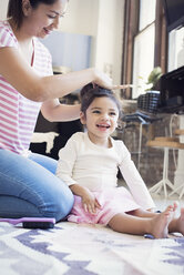 Mother doing her little daughter's hair - WESTF22427