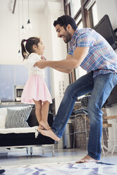 Father balancing his daughter on his foot - WESTF22436