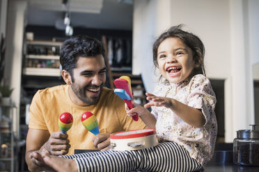 Father and daughter playing music in kitchen - WESTF22440