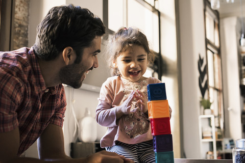 Father and daughter playing with building bricks stock photo