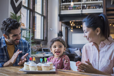 Mutter und Vater essen mit ihrer kleinen Tochter Geburtstagstörtchen - WESTF22450