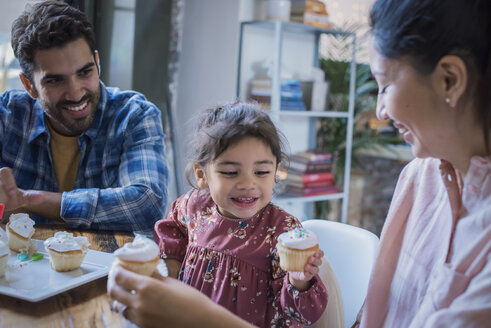 Mutter und Vater essen mit ihrer kleinen Tochter Geburtstagstörtchen - WESTF22454