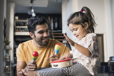 Vater und Tochter musizieren in der Küche, lizenzfreies Stockfoto