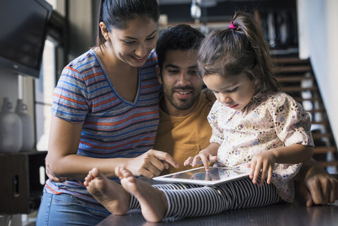 Mutter und Vater beobachten ihre Tochter bei der Nutzung eines digitalen Tablets - WESTF22471