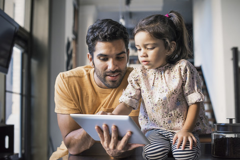 Vater und Tochter benutzen ein digitales Tablet, lizenzfreies Stockfoto