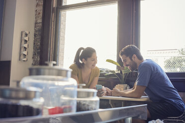 Young couple in kitchen using smart phone - WESTF22474