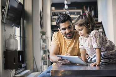 Father and daughter using digital tablet - WESTF22476