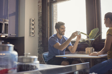 Young couple in kitchen taking smart phone pictures - WESTF22479