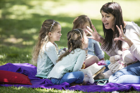 Mutter erzählt Kindern auf einer Picknickdecke Geschichten - ZEF12361