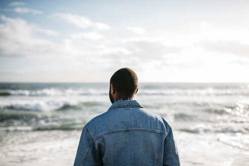 Rückenansicht eines jungen Mannes mit Blick auf das Meer - JRFF01141