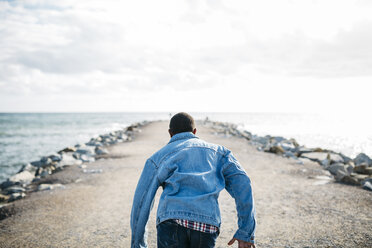 Back view of young man running on jetty - JRFF01156