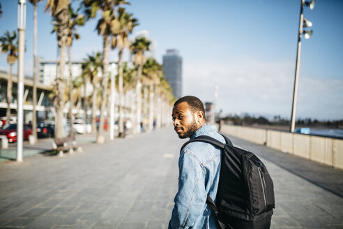 Spanien, Barcelona, junger Mann mit Rucksack auf der Strandpromenade - JRFF01160