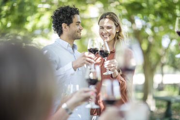 Couple raising a toast together with wine in garden - ZEF12363