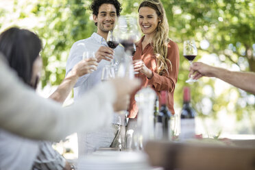 Couple raising a toast together with wine in garden - ZEF12365