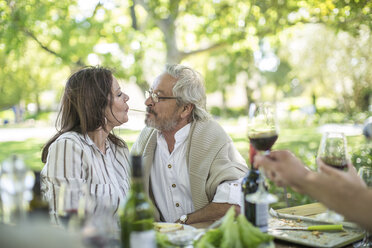 Senior couple sharing spaghetti at outdoor table - ZEF12380