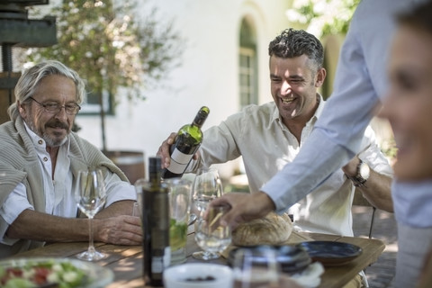 Father and son having wine enjoying family lunch together stock photo