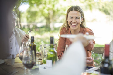Smiling woman at family lunch in garden - ZEF12392