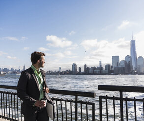 USA, businessman at New Jersey waterfront with view to Manhattan - UUF09690