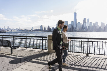 USA, Mann und Frau spazieren am Ufer von New Jersey mit Blick auf Manhattan - UUF09700