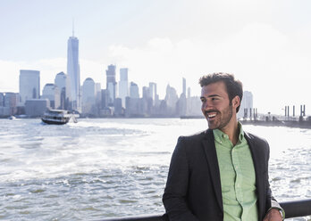 USA, lächelnder Mann am Hafen von New Jersey mit Blick auf Manhattan - UUF09714