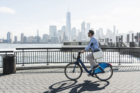 USA, man on bicycle at New Jersey waterfront with view to Manhattan - UUF09717