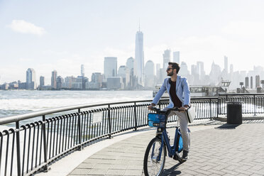 USA, man on bicycle at New Jersey waterfront with view to Manhattan - UUF09719