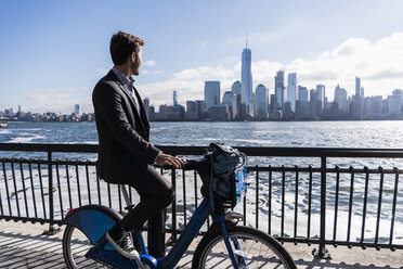 USA, man on bicycle at New Jersey waterfront with view to Manhattan - UUF09724