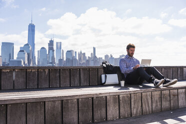 USA, Mann benutzt Tablet am Hafen von New Jersey mit Blick auf Manhattan - UUF09738