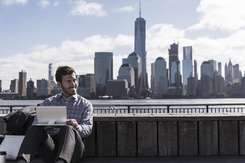 USA, Mann benutzt Tablet am Hafen von New Jersey mit Blick auf Manhattan - UUF09739