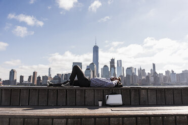 USA, Mann ruht sich am Ufer von New Jersey mit Blick auf Manhattan aus - UUF09741