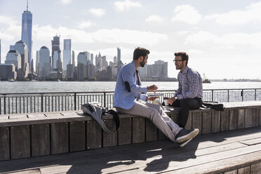 USA, two businessmen working at New Jersey waterfront with view to Manhattan - UUF09743