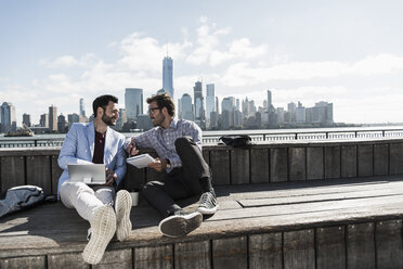USA, two businessmen working at New Jersey waterfront with view to Manhattan - UUF09744