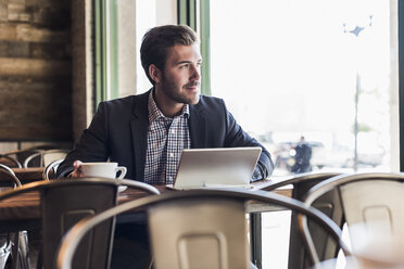 Businessman using tablet in a cafe - UUF09754