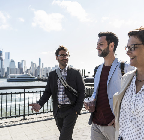 USA, Kollegen bei einem Spaziergang am Ufer von New Jersey mit Blick auf Manhattan, lizenzfreies Stockfoto