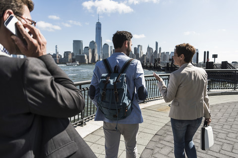 USA, Kollegen bei einem Spaziergang am Ufer von New Jersey mit Blick auf Manhattan, lizenzfreies Stockfoto