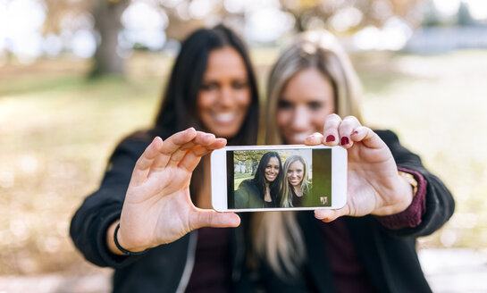 Handyfoto von zwei lächelnden jungen Frauen - MGOF02758